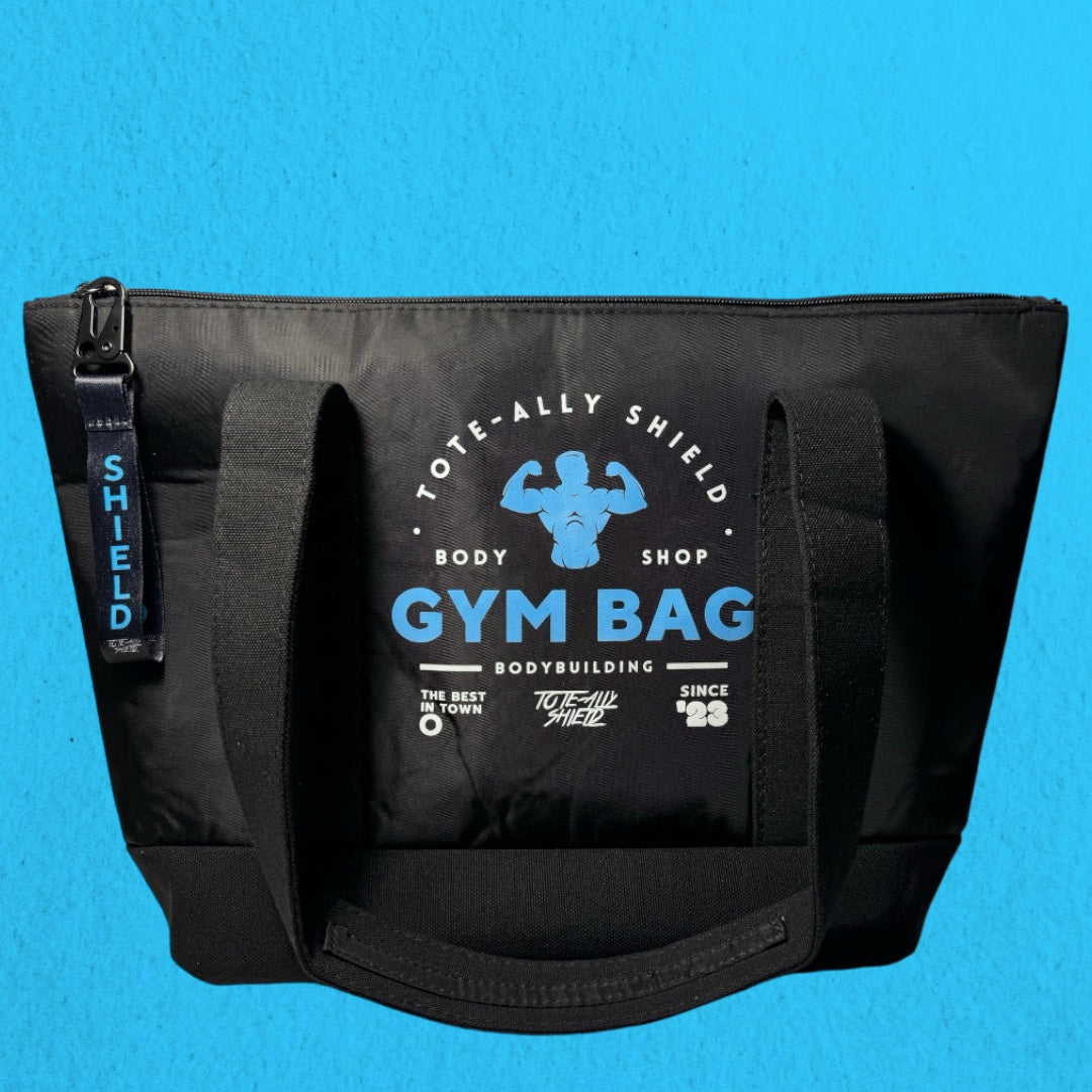 1. Black nylon gym bag with canvas reinforcement, featuring TOTE-ALLY SHIELD GYM print on front and rear sides.
2. Top view of TOTE-ALLY SHIELD Gym Bag, showcasing durable construction and TOTE-ALLY SHIELD  puller on top zip.
3. Inside view of TOTE-ALLY SHIELD  Gym Bag, highlighting zip pocket for separated storage of gym essentials. 
4. TOTE-ALLY SHIELD  Gym Bag dimensions: Length 45cm, Height 30cm, Depth 15cm.
5. Close-up of TOTE-ALLY SHIELD  puller on top zip for easy access to gym bag contents.
